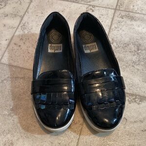 Fit flip black shiny frilly loafers style black shed with small mark on one toe.